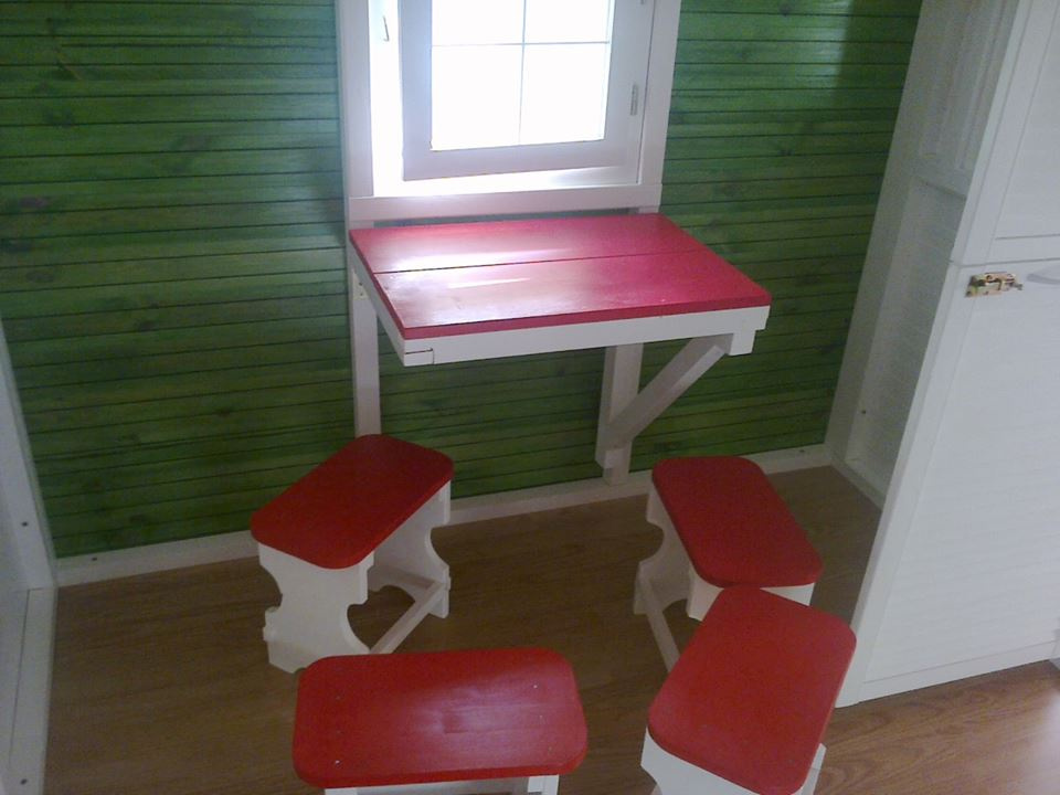 Interior cu 4 scăunele-taburet și o masă rabatabilă la perete