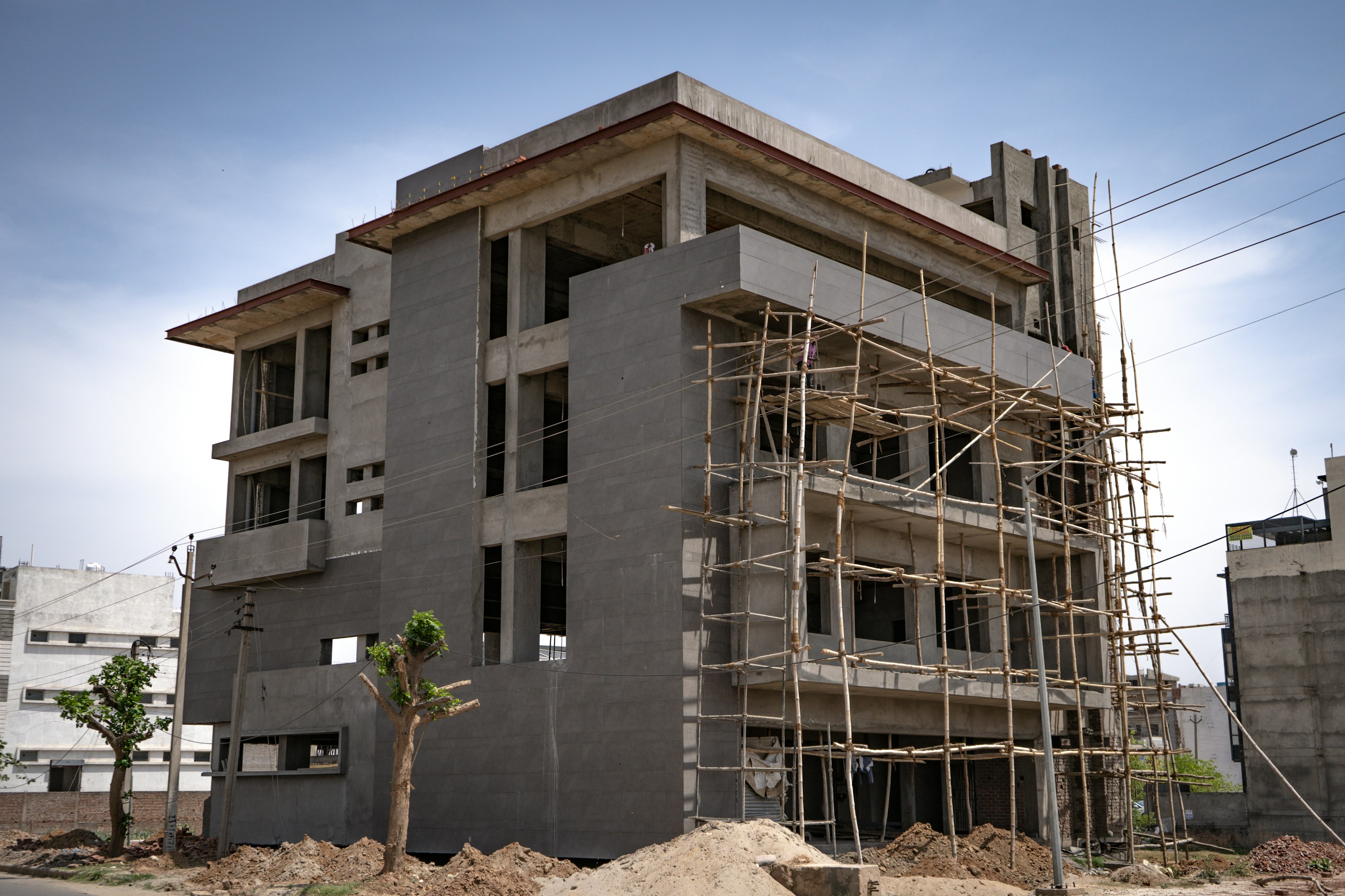 Engineers reviewing plans outside sustainable building with rooftop solar panels and energy-efficient HVAC system