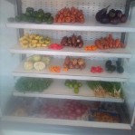 Femme choisissant des produits de viande emballés dans un rayon de supermarché avec service en libre-service.