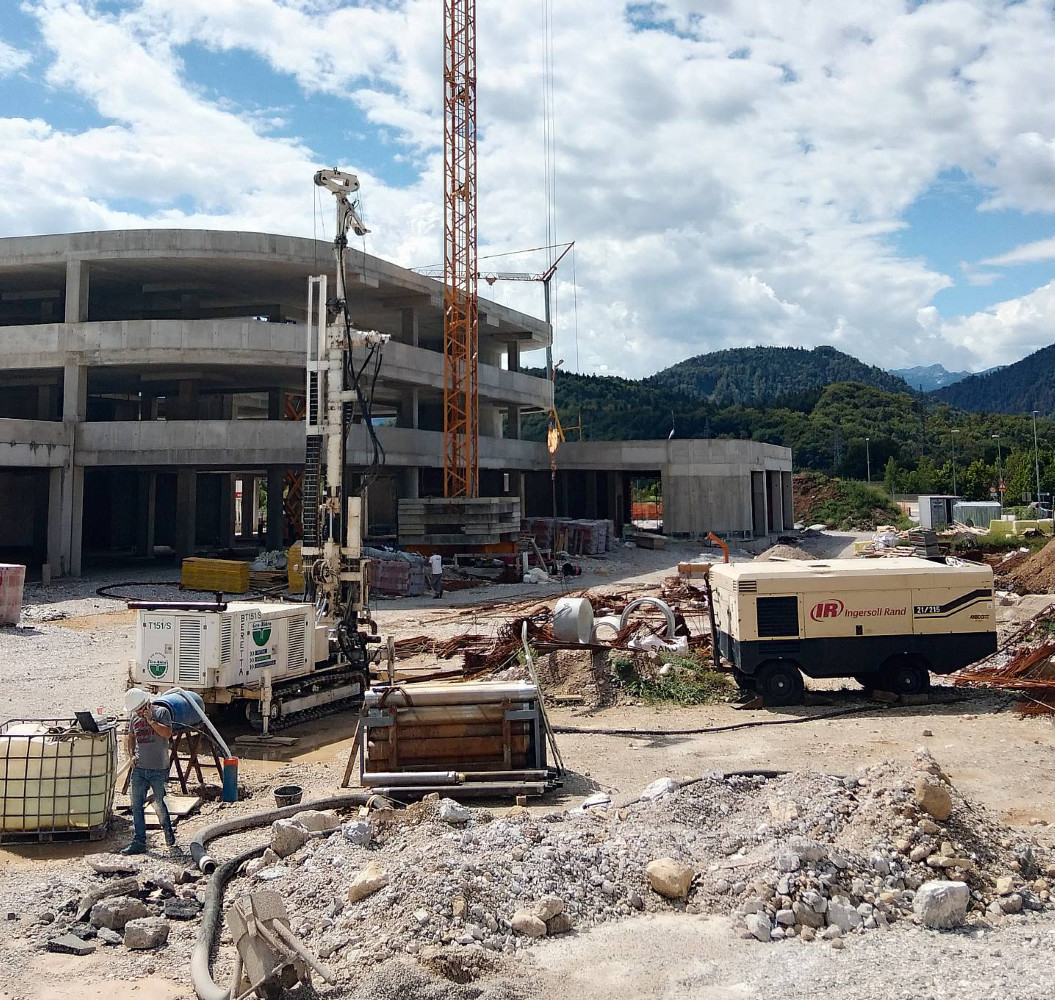 Vrtalni stroj in kompresor pri izvedbi vrtine za poslovni objekt