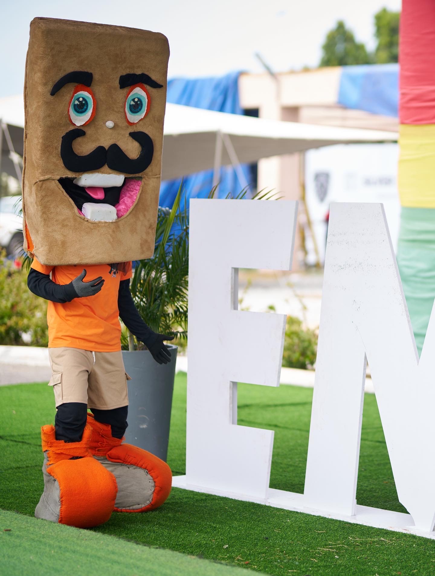 Three colorful anthropomorphic animal mascots wearing sports uniforms, standing together and smiling.