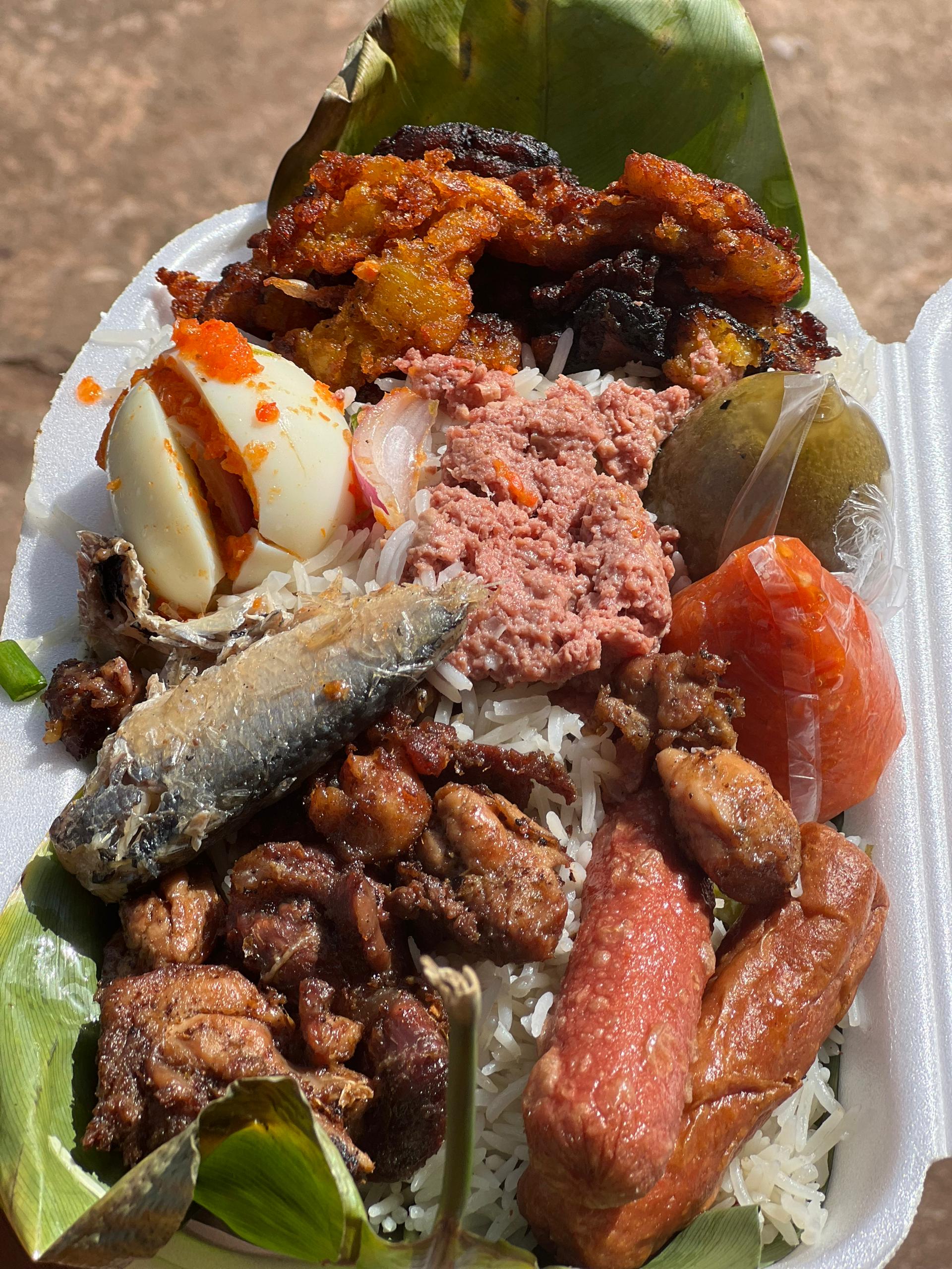 Elegant dining setup with a wooden table featuring roast chicken, fries, wine glasses, salads, and ambient lighting.