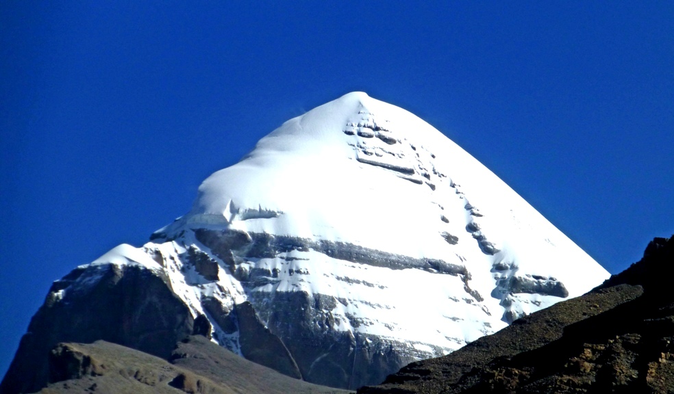 Die Südseite des „Großen Schneejuwels“ (Gang Rinpoche) 6.638 m
Am Kailash kam es der Sage nach um 1100 n. Chr. zu einem Wettkampf zwischen Milarepa und seinem Bön-Kontrahenten Naro Bönchung. Das Rennen zum Gipfel gewann Milarepas. Damit siegte der Buddhismus über die Bön