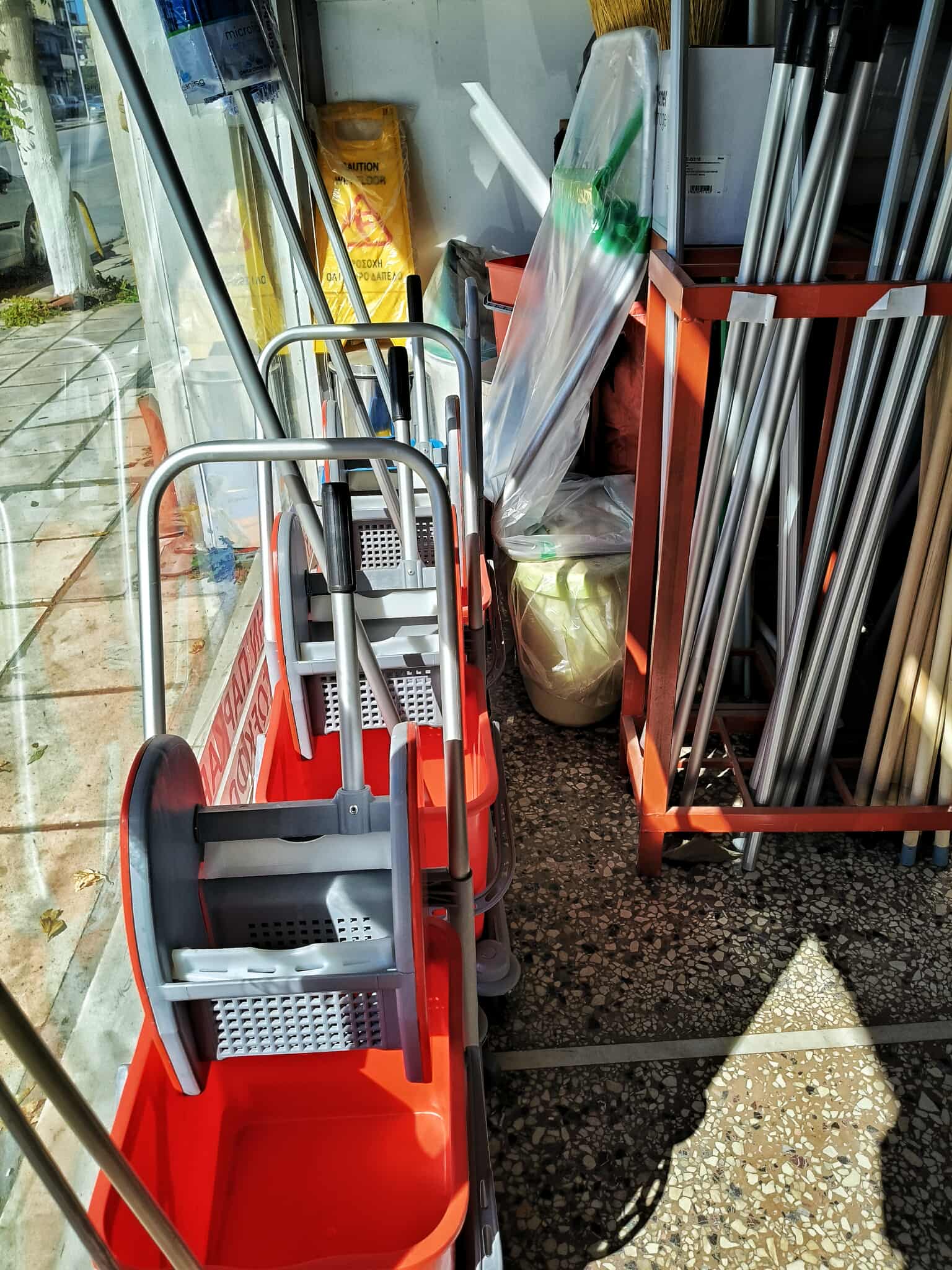 Σύγχρονο γραφείο με ανθρώπους που εργάζονται σε χώρους εργασίας με ανοικτή διάταξη, μεγάλα παράθυρα και ψηφιακές οθόνες.