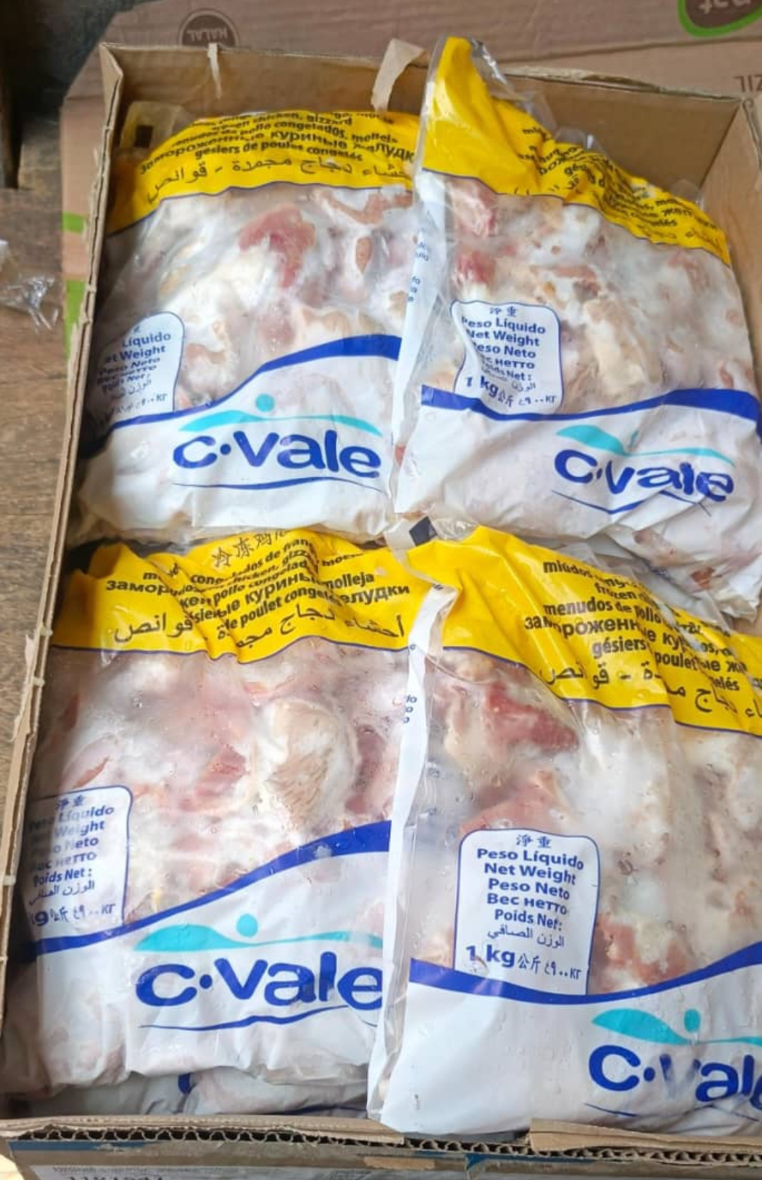 Fresh salmon fillets on a wooden board surrounded by cherry tomatoes, green herbs, and sliced vegetables.