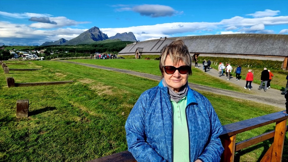 Vor dem Langhaus eines Wikingerfürsten. Es ist das längste rekonstruierte Langhaus der Welt