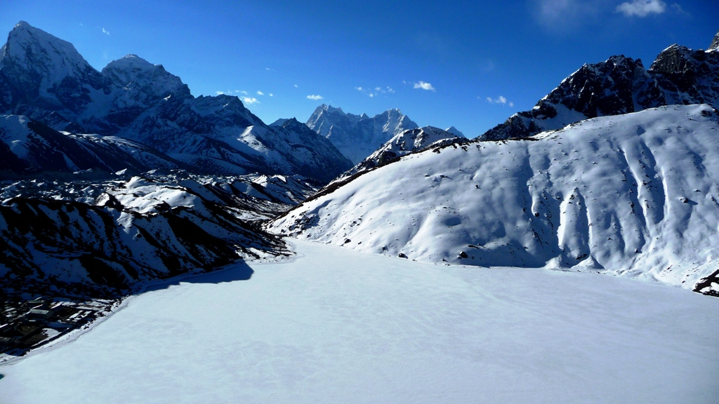 Blick auf den zugefrorenen Gokyo See
Die Lodge-Siedlung Gokyo ist die einzige größere Ansiedlung im Tal des Ngozumpa-Gletschers, dem größten Eisstrom Nepals, welcher vom Massiv des Cho Oyu (8188 m) gespeist wird. Sie liegt auf einer Höhe von 4860 m direkt am dritten der vier Gokyo-Seen