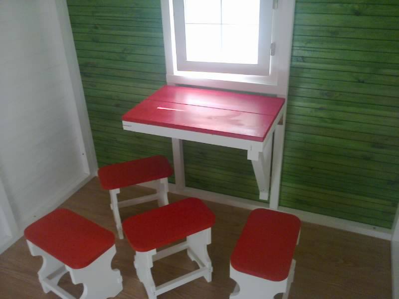 Interior cu 4 scăunele-taburet și o masă rabatabilă la perete