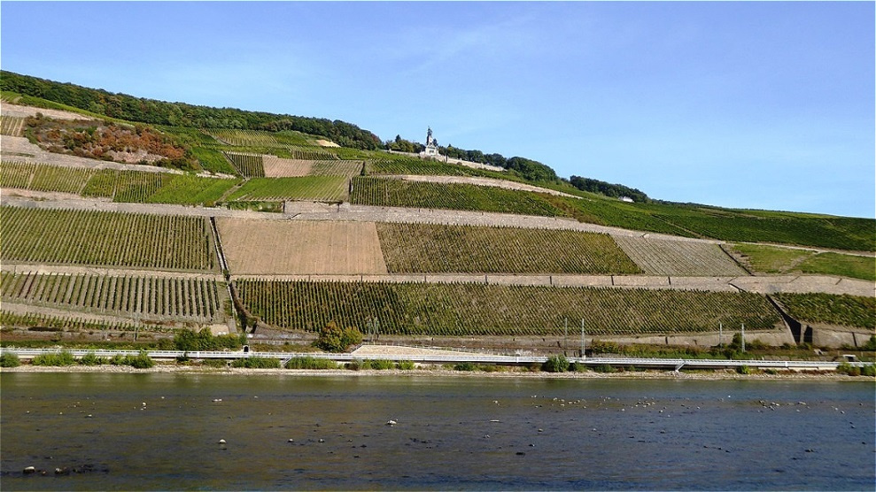
Das Niederwalddenkmal liegt am Rand des Landschaftsparks Niederwald oberhalb der Stadt Rüdesheim am Rhein. Zu seinen Füßen befinden sich die Weinlagen des Rüdesheimer Berges
