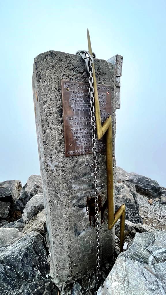 Der Gipfelstein mit dem gezackten Blitz des Zeus