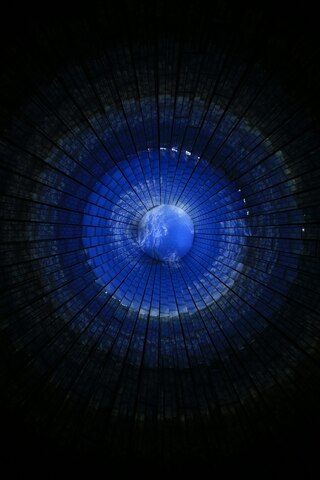 View of Earth from a dome-like structure with a radial pattern in shades of blue and black. View of Earth from a dome-like structure with a radial pattern in shades of blue and black.