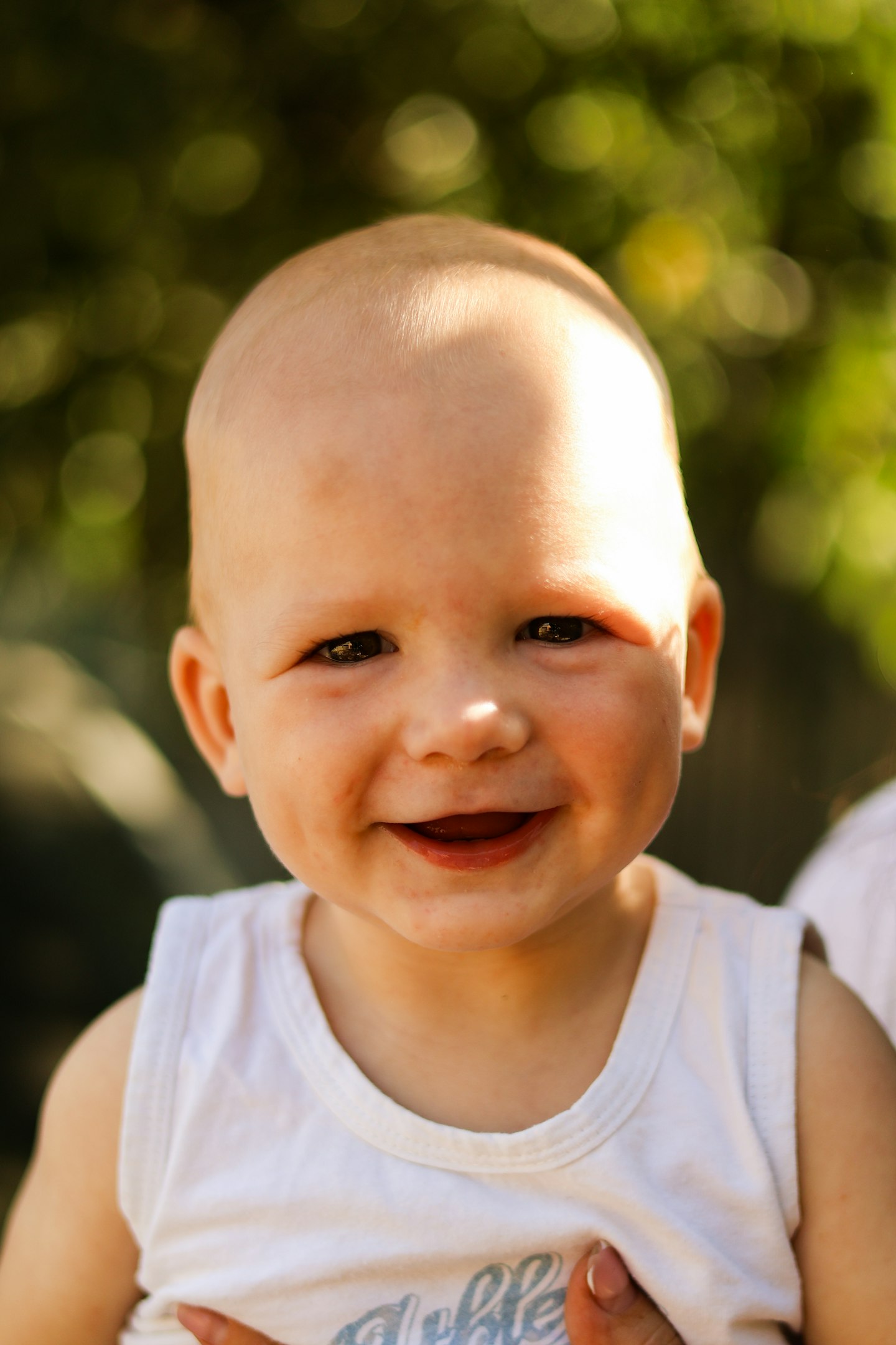 a smiling baby wearing a white shirt