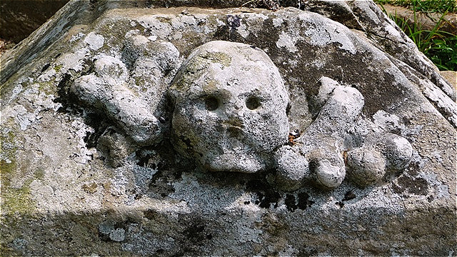 Die Darstellung am Fuß des Pilgerkreuzes erinnert an die Vergänglichkeit des Lebens