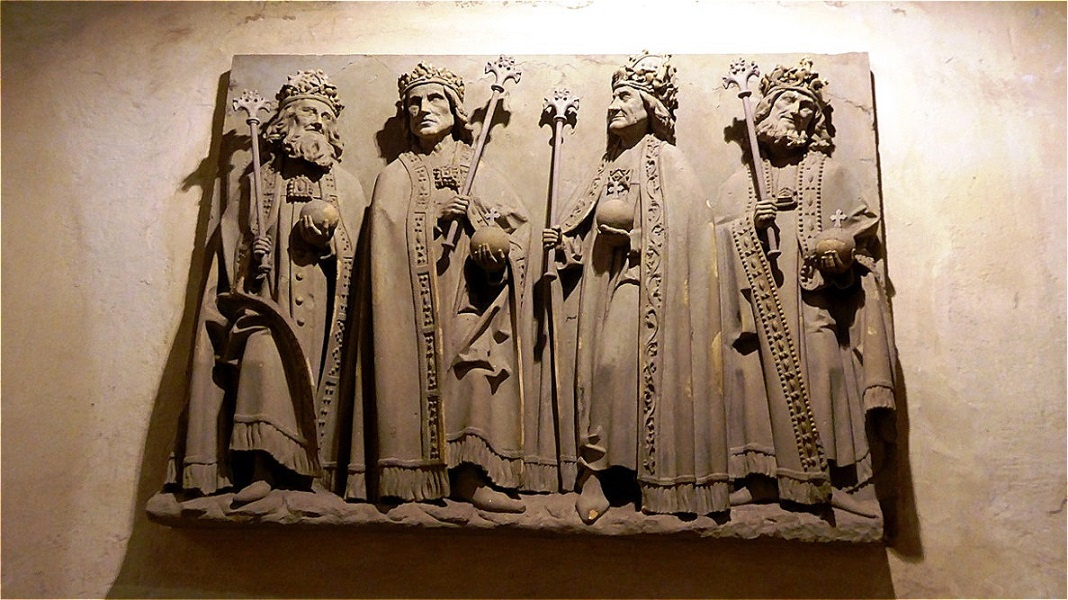 Steinrelief der salischen Kaiser - sie tragen Zepter, Reichsapfel und die mittelalterliche Bügelkrone

