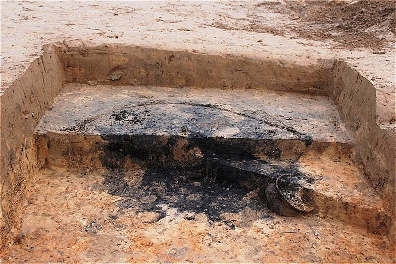 Brandbestattung - die Brandschicht aus Holzkohle und Asche lassen erkennen,dass die Leichenverbrennung direkt am Standort des Grabhügels stattgefunden hat