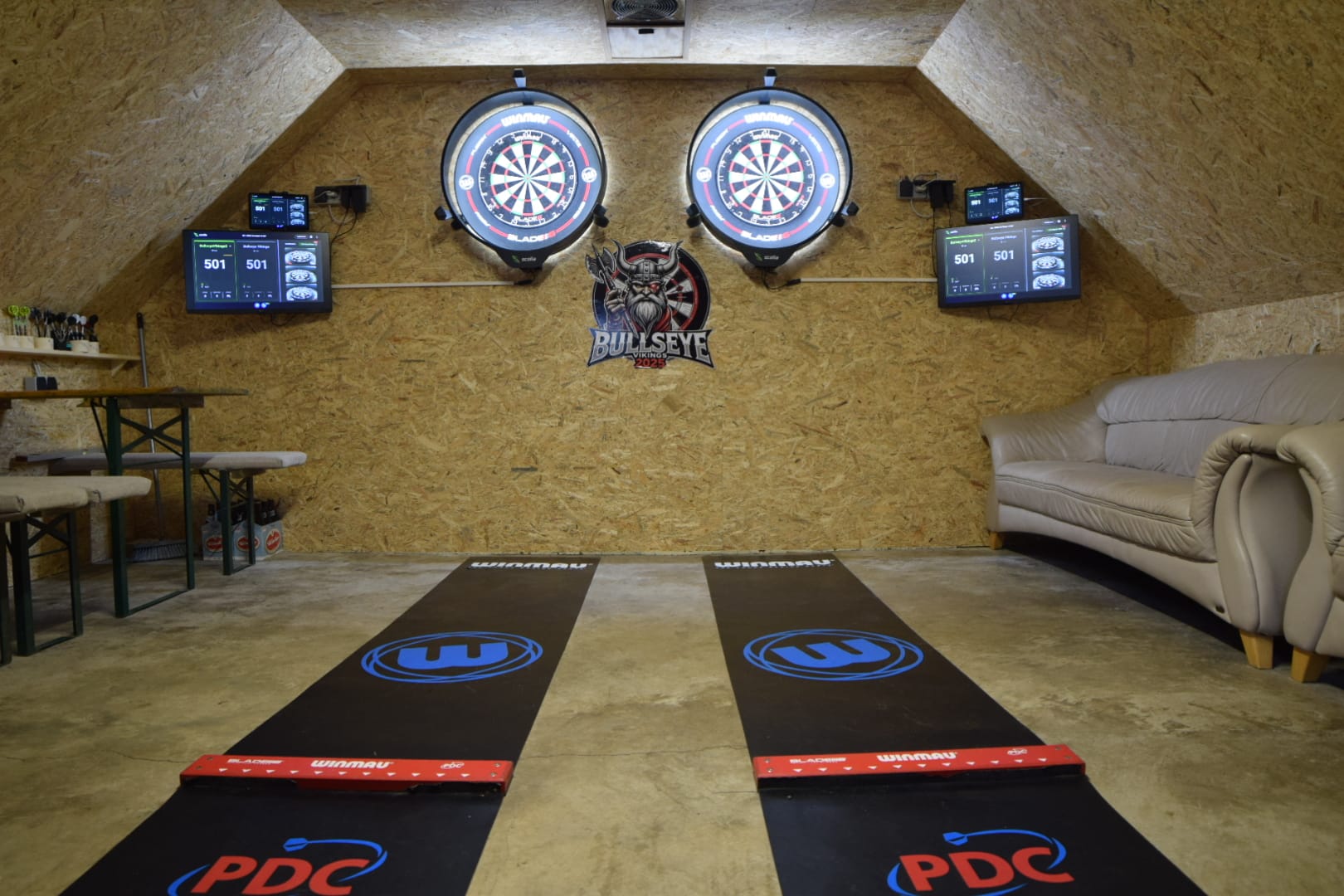 Nahaufnahme einer Dartscheibe mit mehreren roten Pfeilen im Zentrum.
