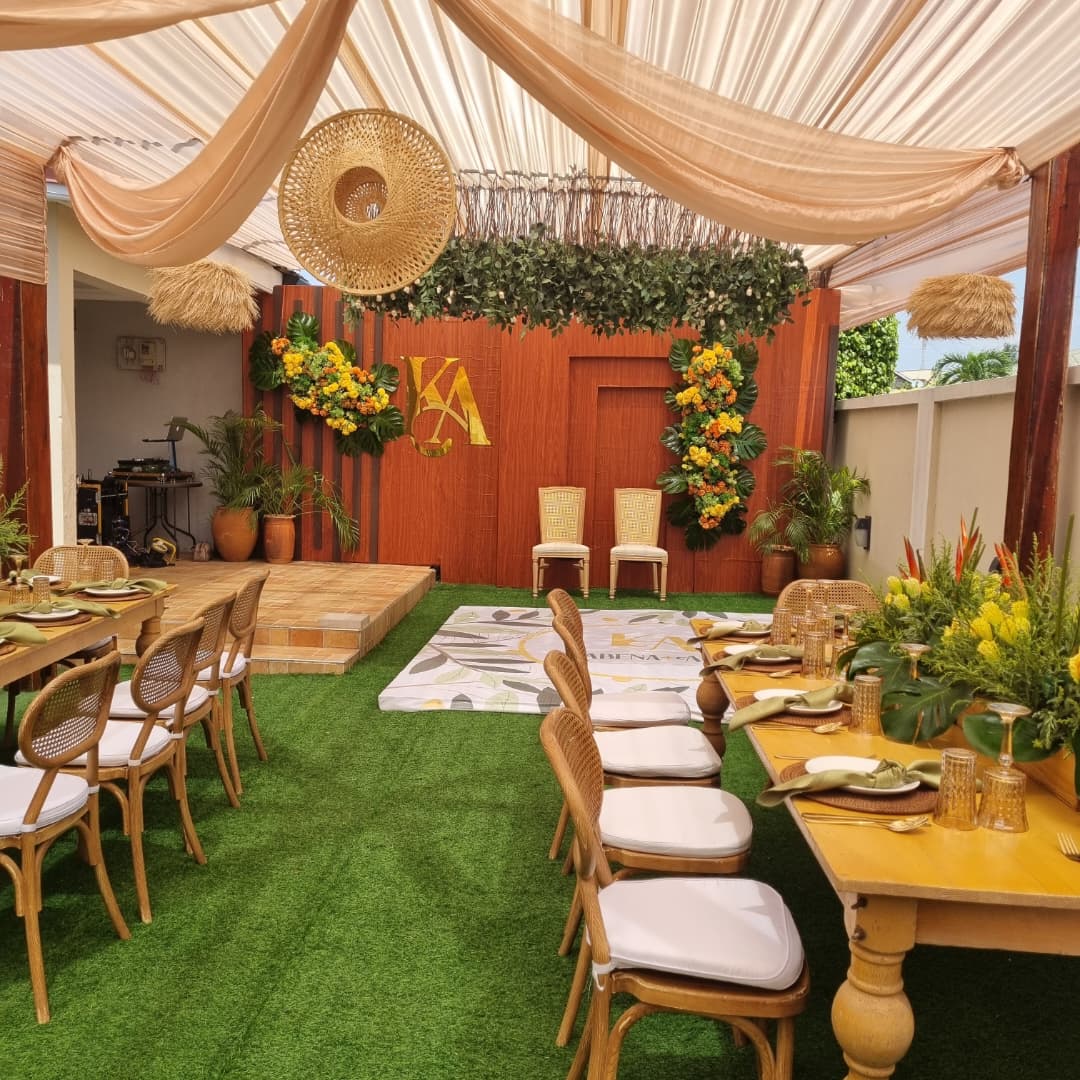 Elegant hallway with floral decor, pink trees, and mood lighting leading to a floral backdrop in a luxurious setting.