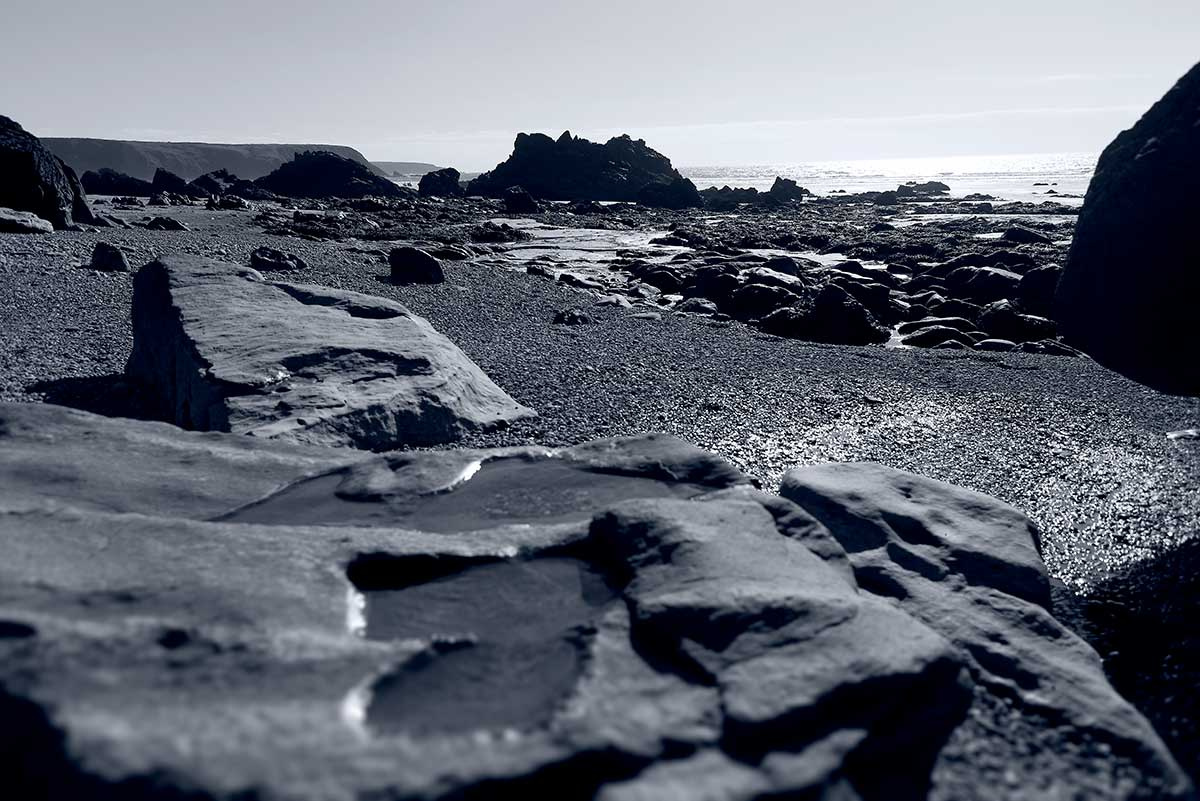 black and white photograph of worn rocks at Marloes Beach Pembrokeshire Wales by Mark Lloyd Williams
