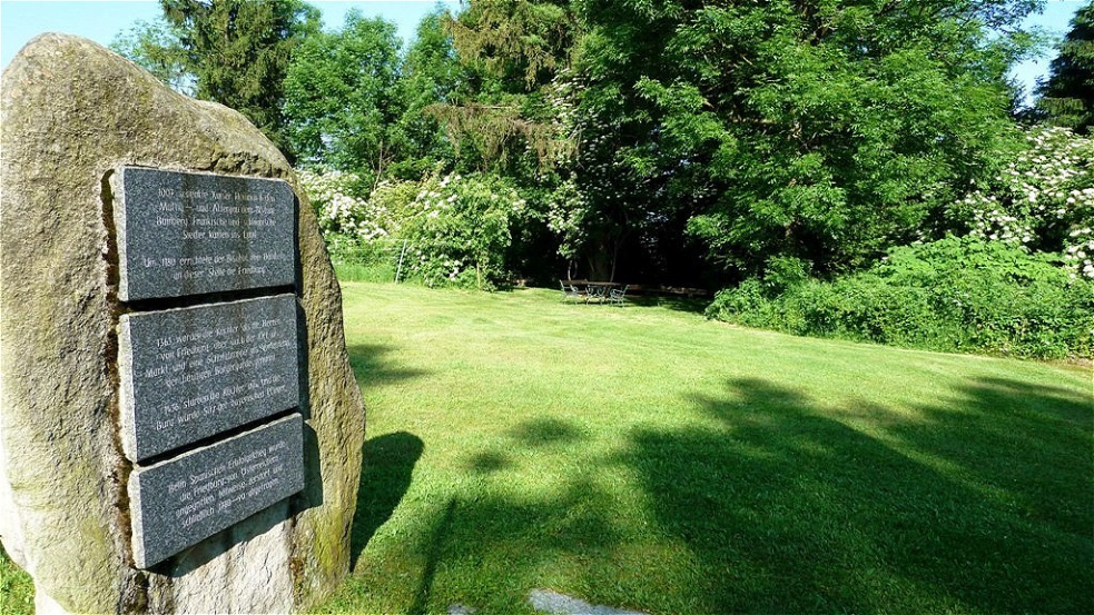 Gedenkstein mit Blick auf den schattigen Rastplatz