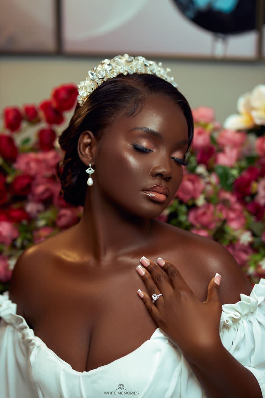 Smiling woman with long wavy brown hair in a bright indoor setting.