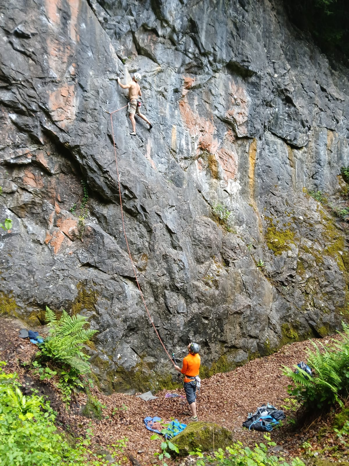 Hiker with orange backpack overlooking scenic mountainous landscape with lake.