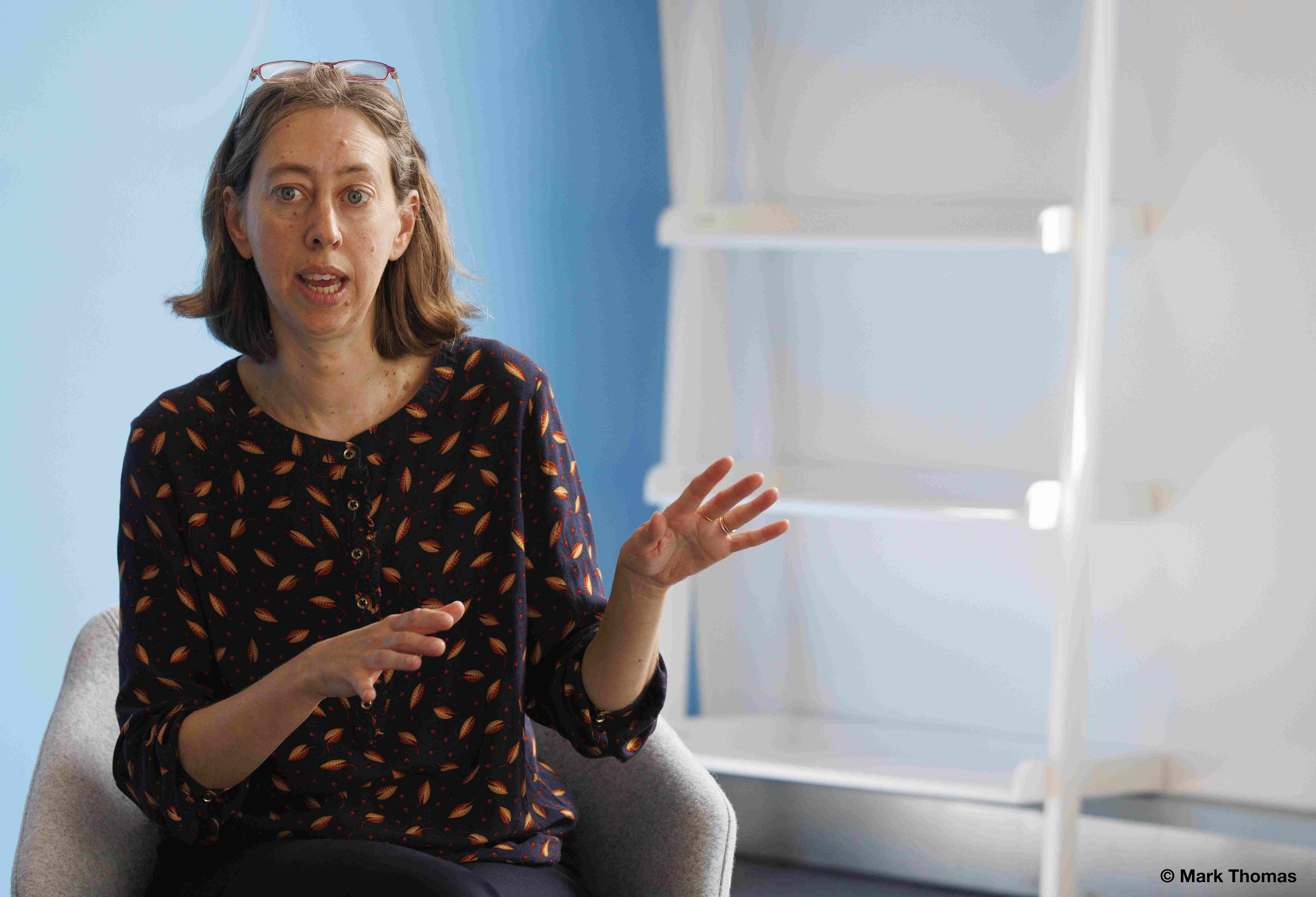Laura Davison, in a office, speaking in an animated manner.