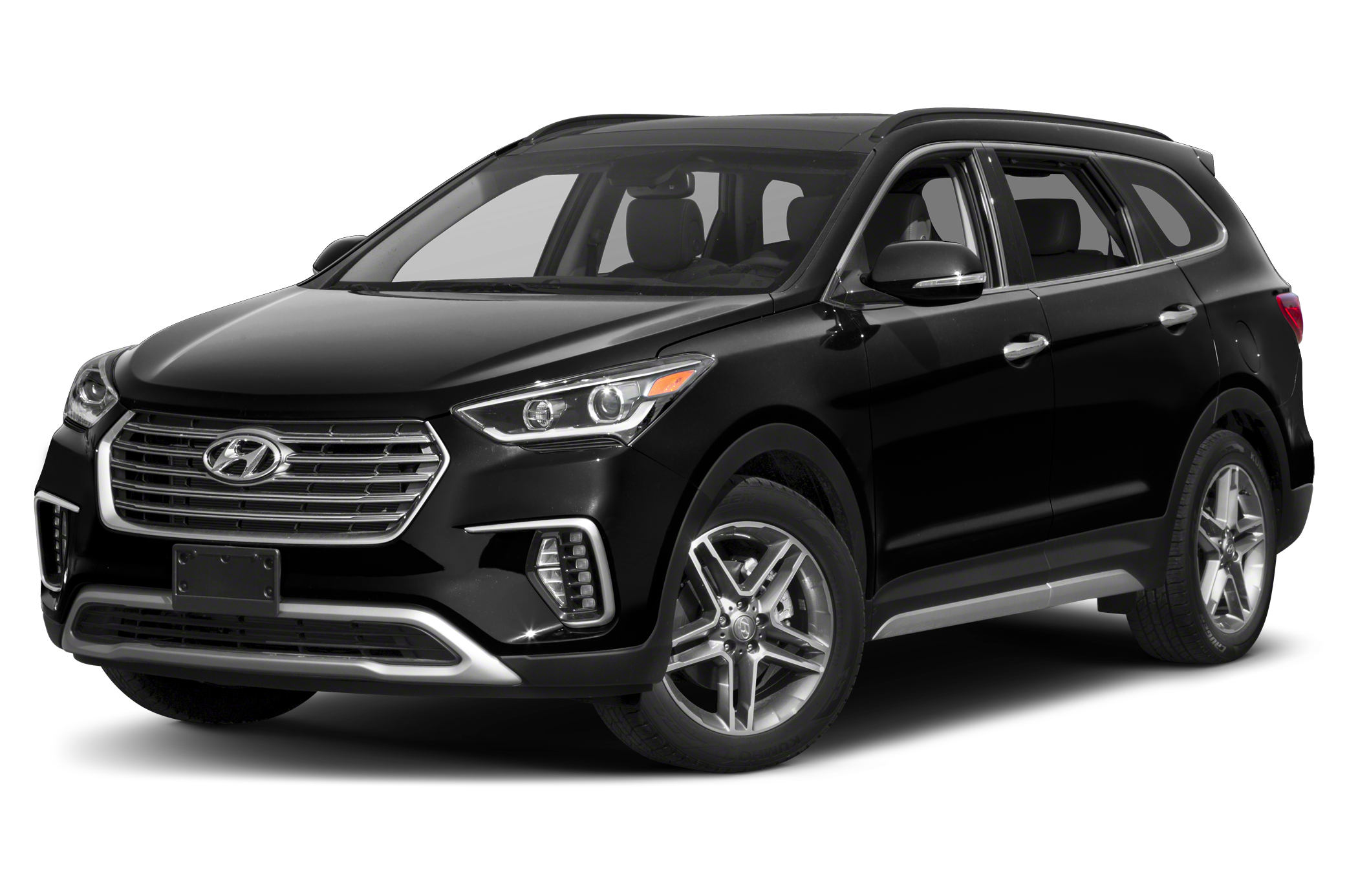 Luxury SUV parked in modern courtyard with palm trees and white buildings.