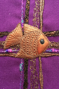 Poisson chrétien figuré en textile sur une croix