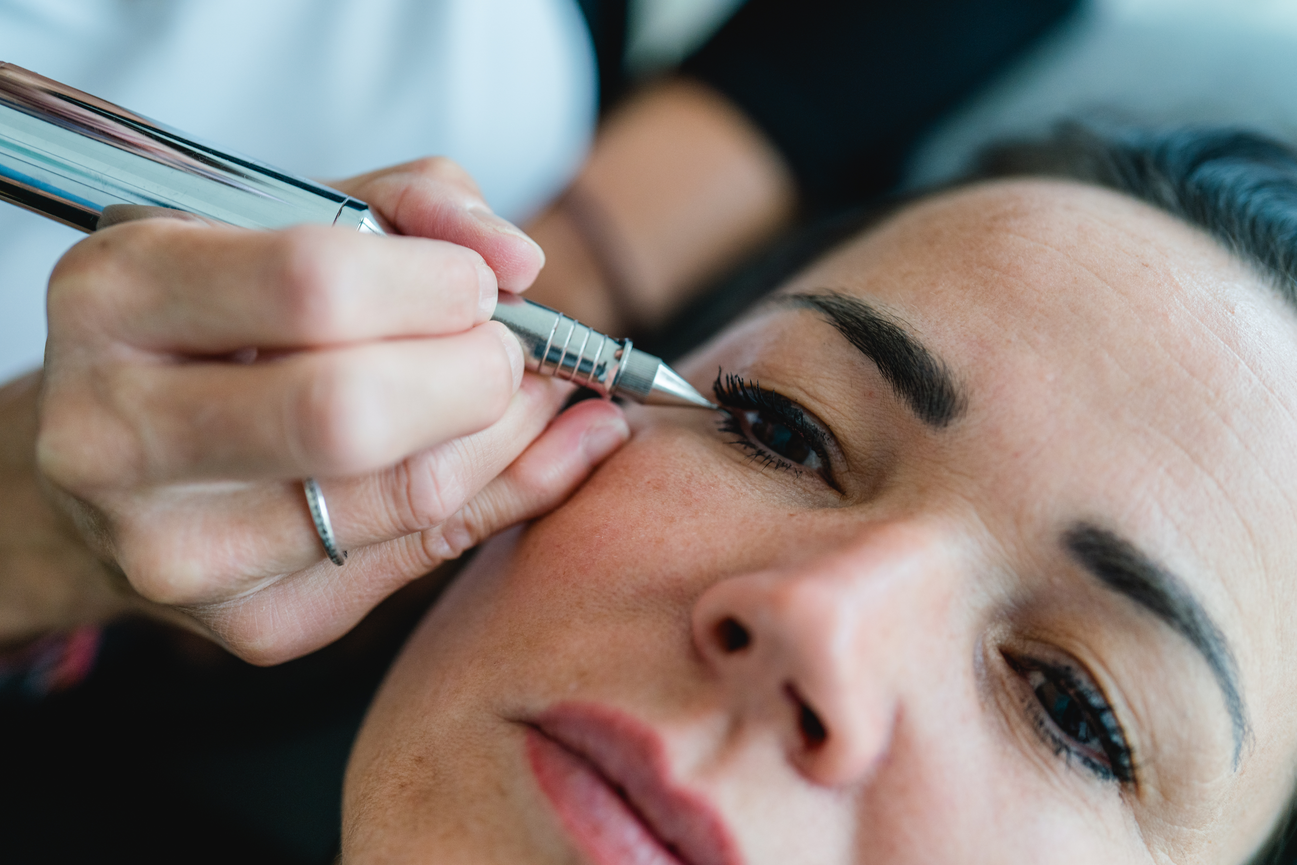 Nahaufnahme einer Frau mit blauen Augen, perfektem Make-up und blonden Haaren.