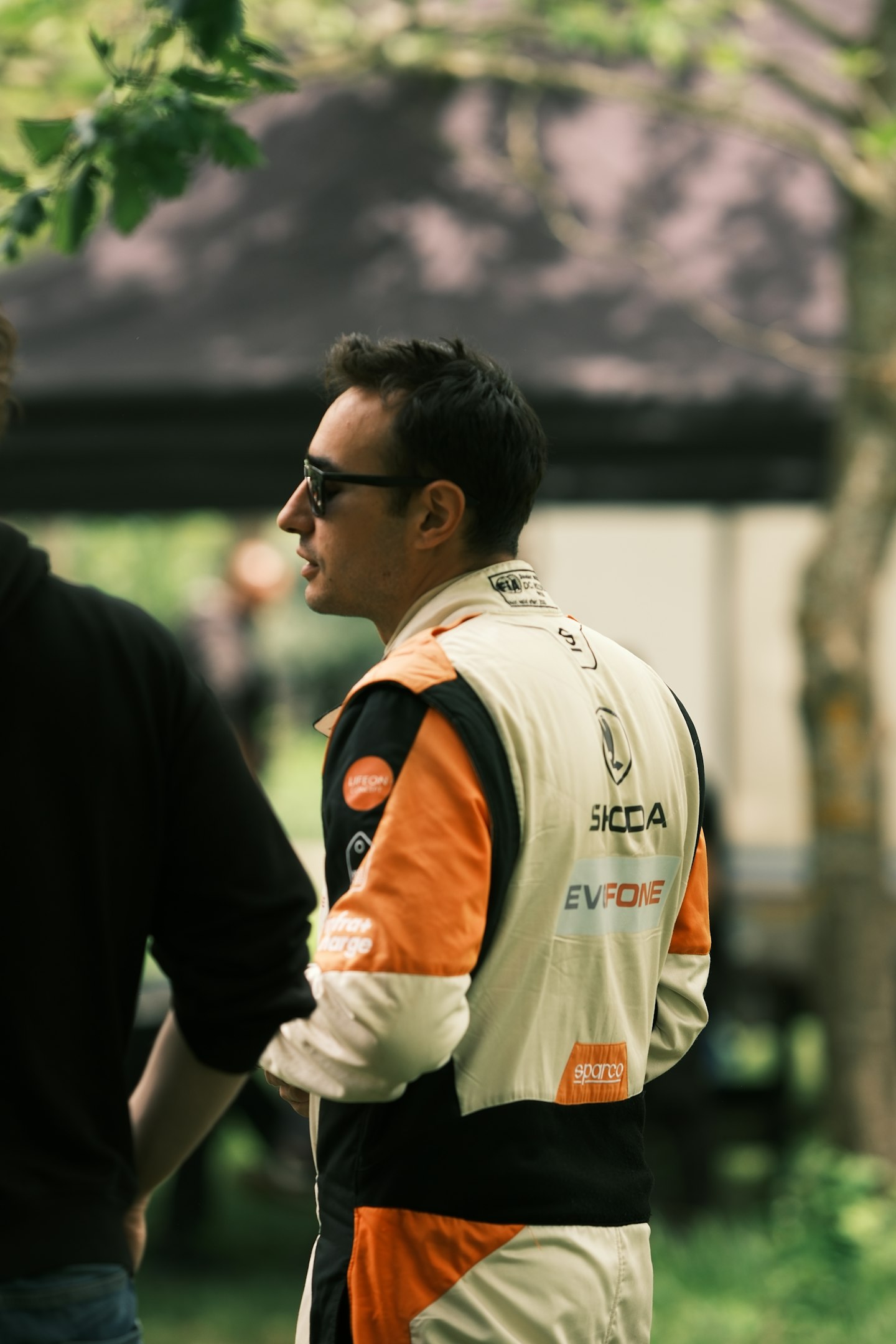 a man standing next to another man in a park