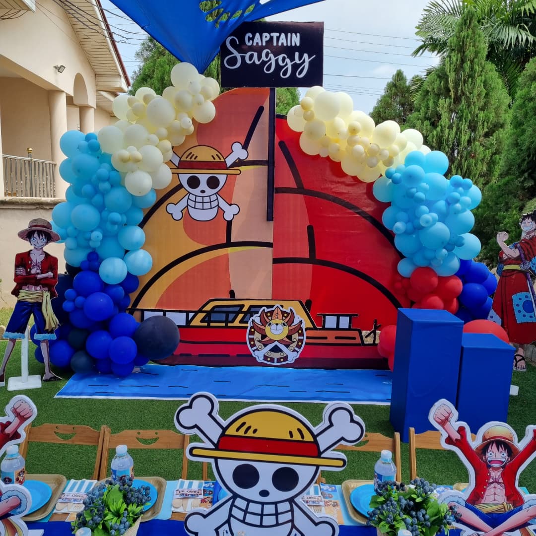 Elegant event venue with floral decorations, hanging greenery, and illuminated chandeliers surrounding a stage with 'Hallo Events' signage.